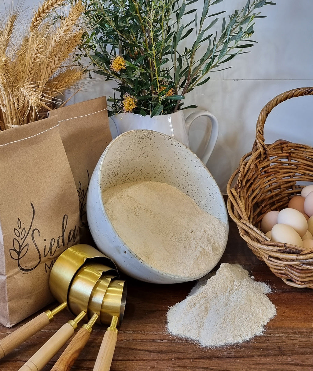 Stone-milled flour from the Big Flour Box by Sieda Milling, shown with baking ingredients for bulk home baking
