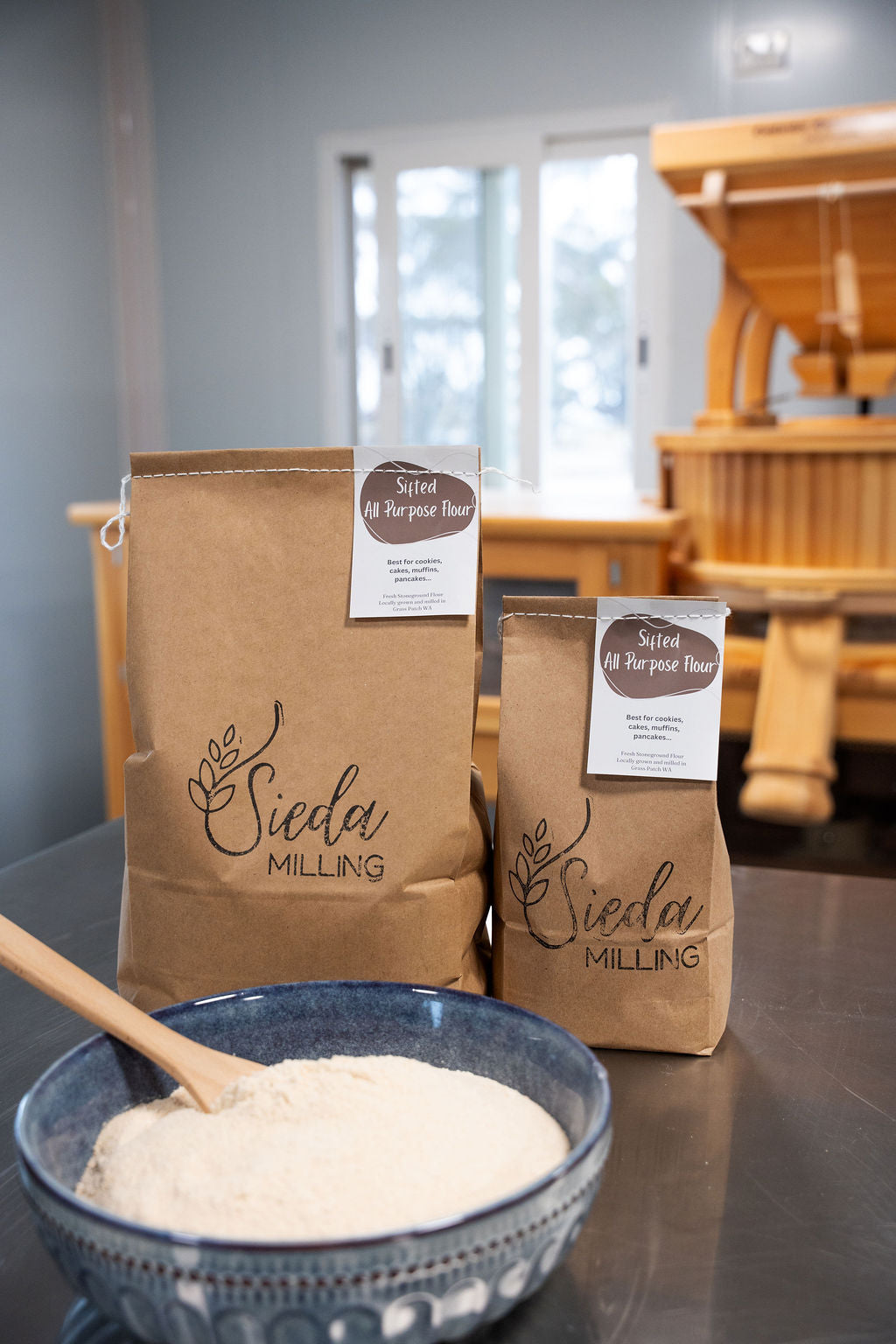 Two bags of Sieda Milling flour with a bowl of Sifted all purpose flour made from stone-milled wheat, ideal for cakes, muffins, and everyday baking