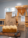 Stone-milled wholegrain bread flour by Sieda Milling, shown with fresh baked bread in a small batch milling setting