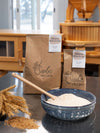 Stone-milled wholegrain all purpose flour by Sieda Milling, shown with flour and traditional milling equipment