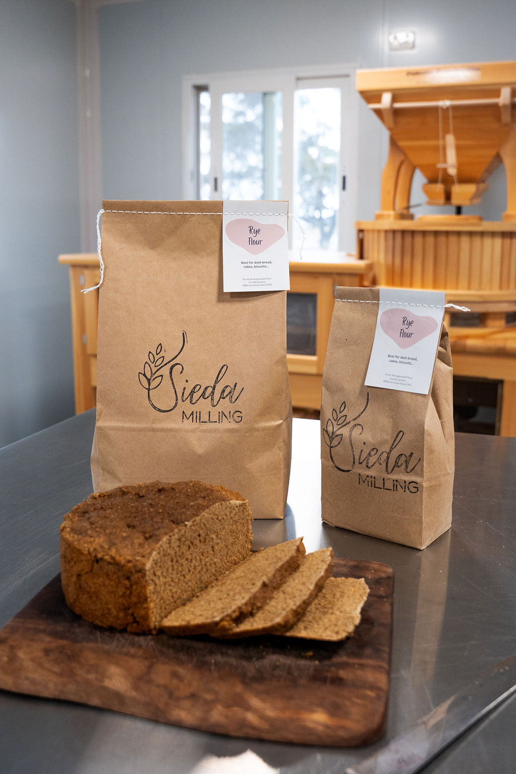 Stone-milled spray-free rye flour by Sieda Milling, shown with sliced rye bread and artisan baking setup