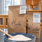 Two bags of Sieda Milling flour with a blue bowl filled with Wholegrain bread flour made from stone-milled wheat, ideal for sourdough and artisan bread baking